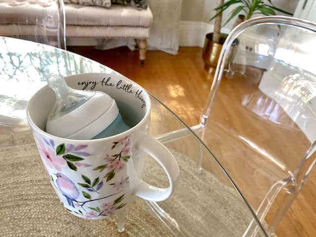 warming a baby milk bottle in a mug