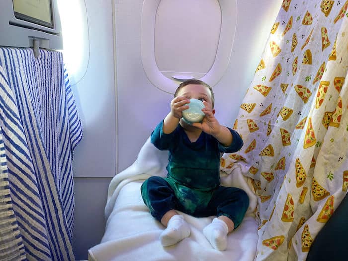 baby on plane with blankets covering seat