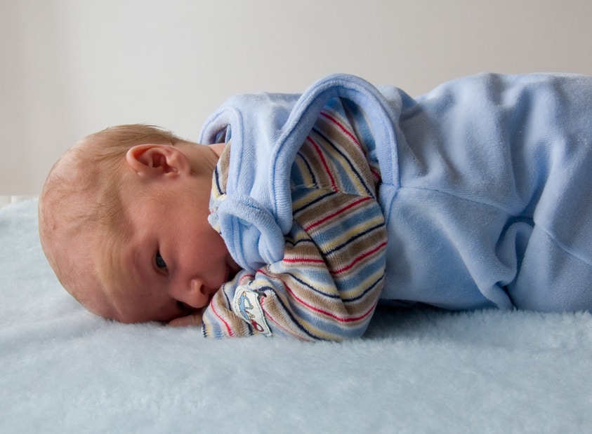 newborn baby rolling on belly