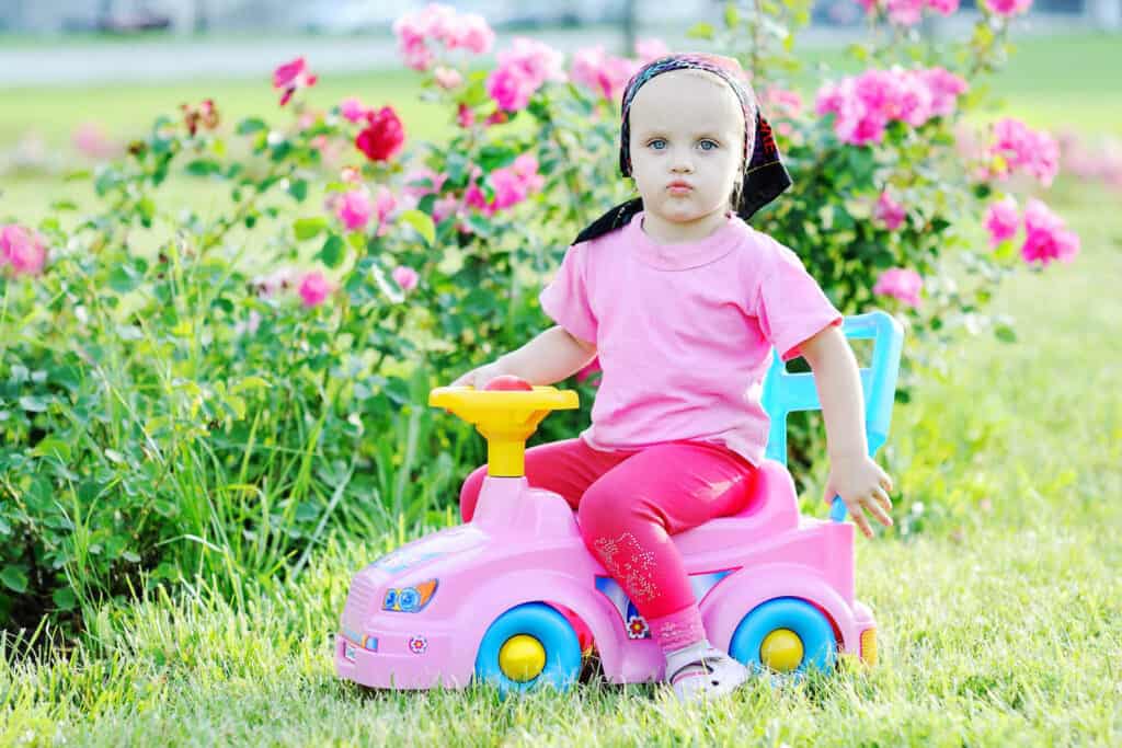 badass little girl on ride-on pink car