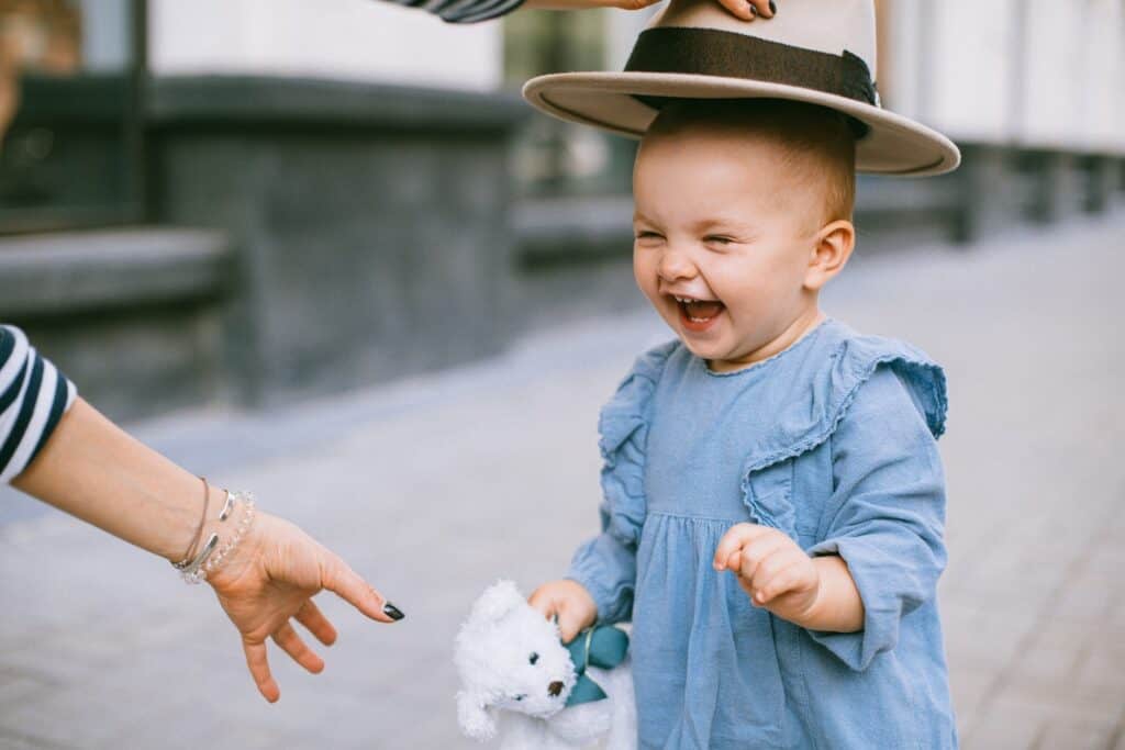 baby laughing wearing hat