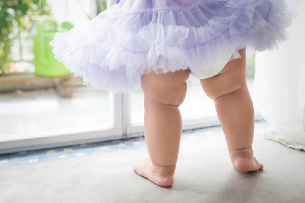 baby girl standing wearing tutu