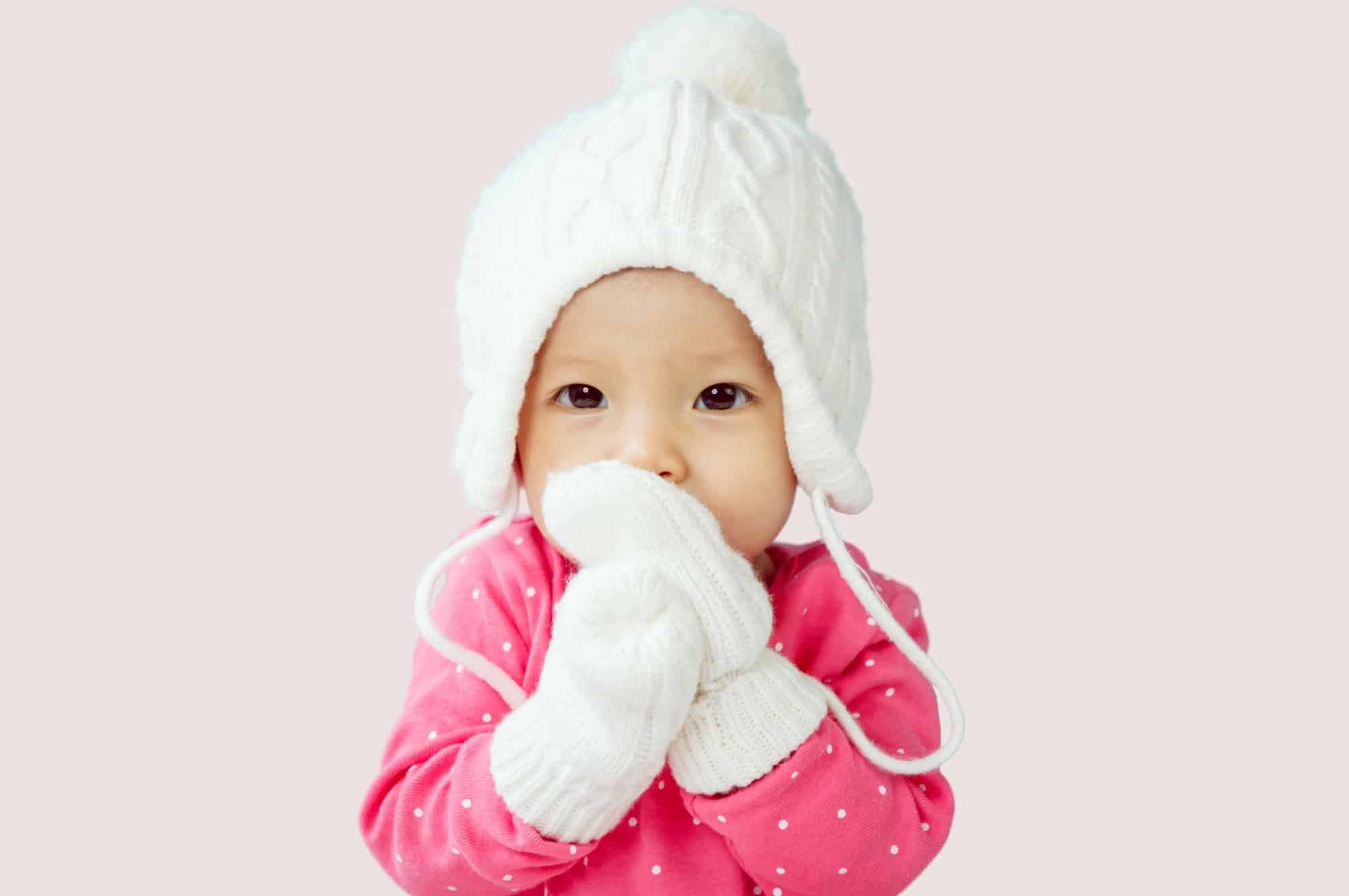 baby girl wearing hat and mittens