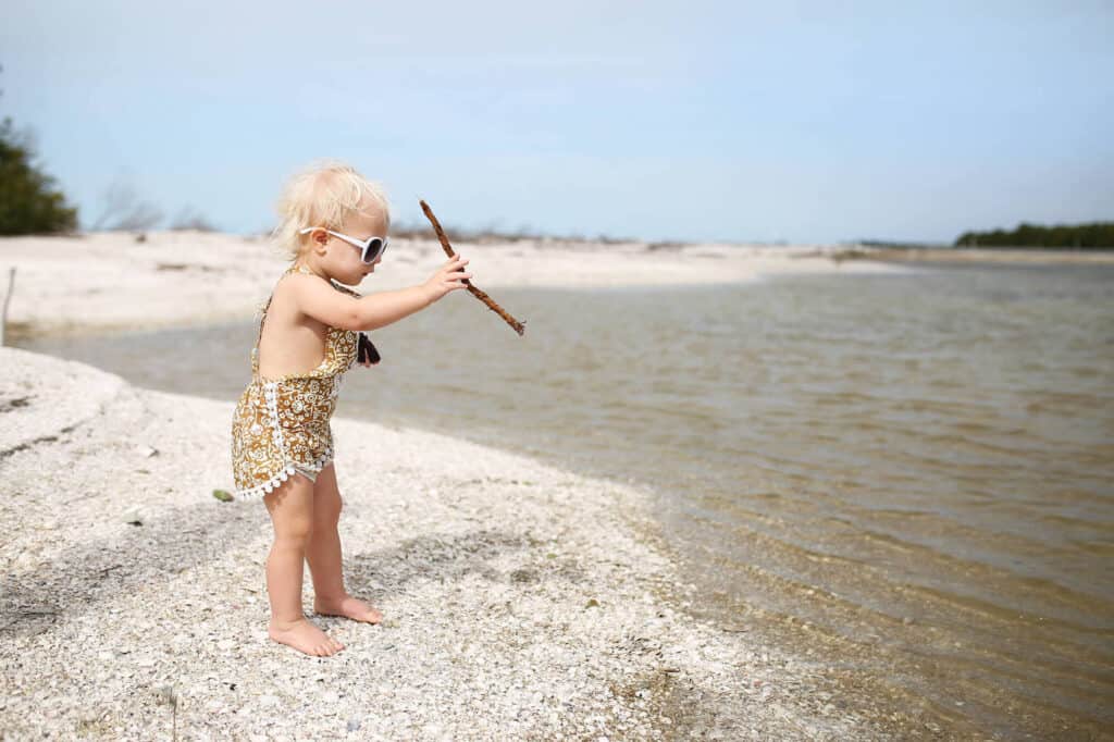 baby girl standing shoreline water nature