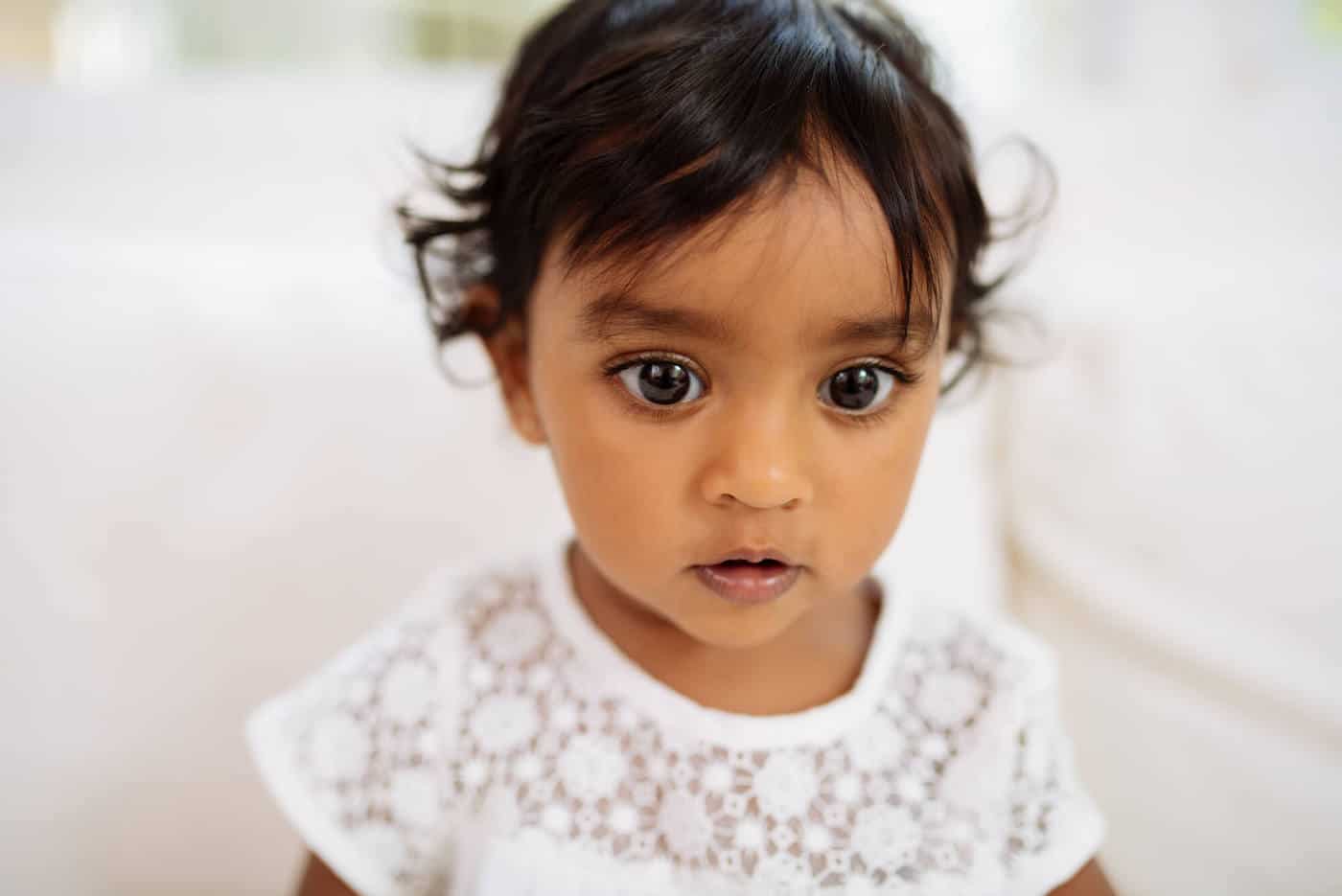 little girl with dark eyes and white dress