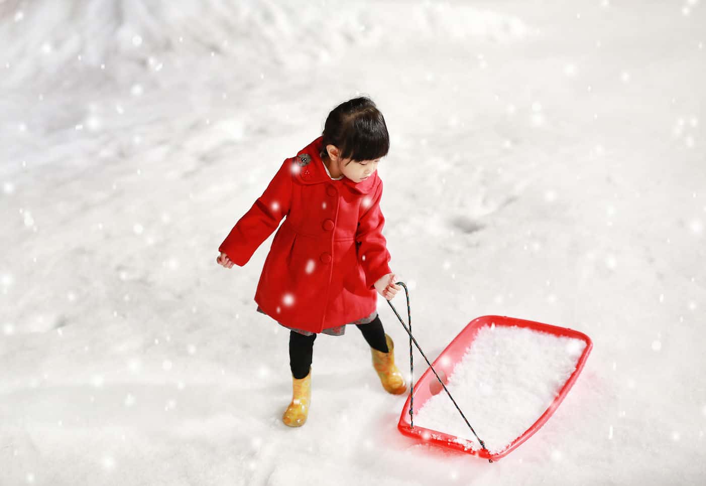 little girl in snow with sled