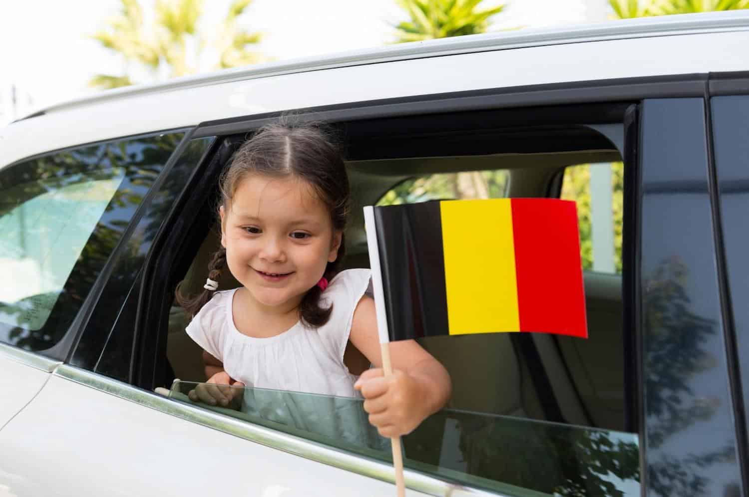 little girl in car holding german flag