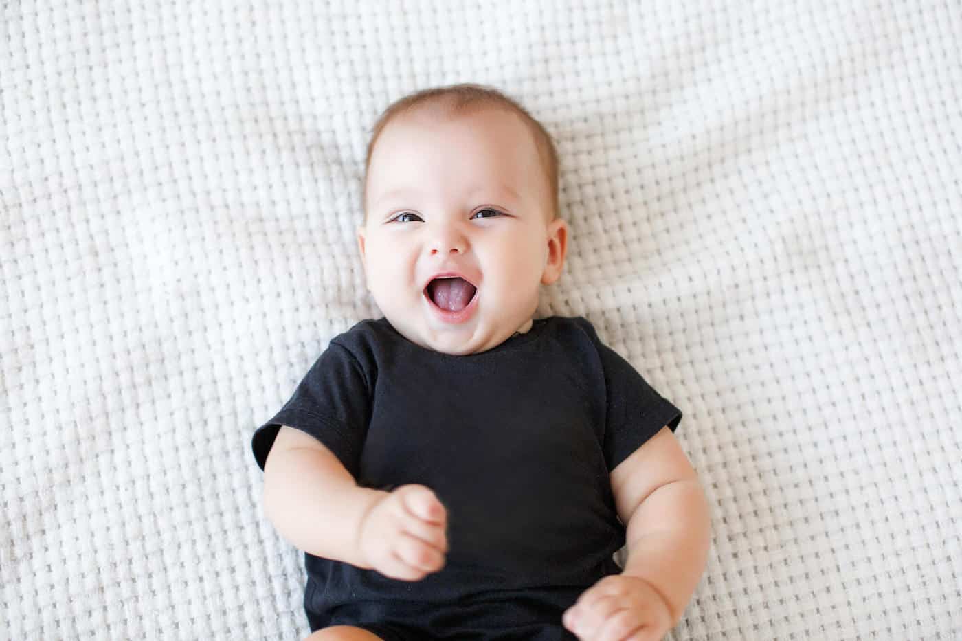 baby boy laughing lying on back