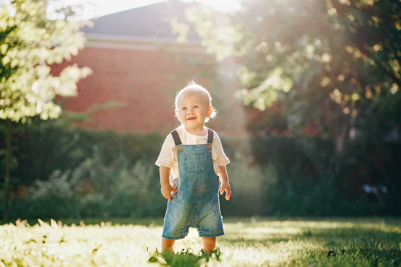 baby boy in denim overalls outside