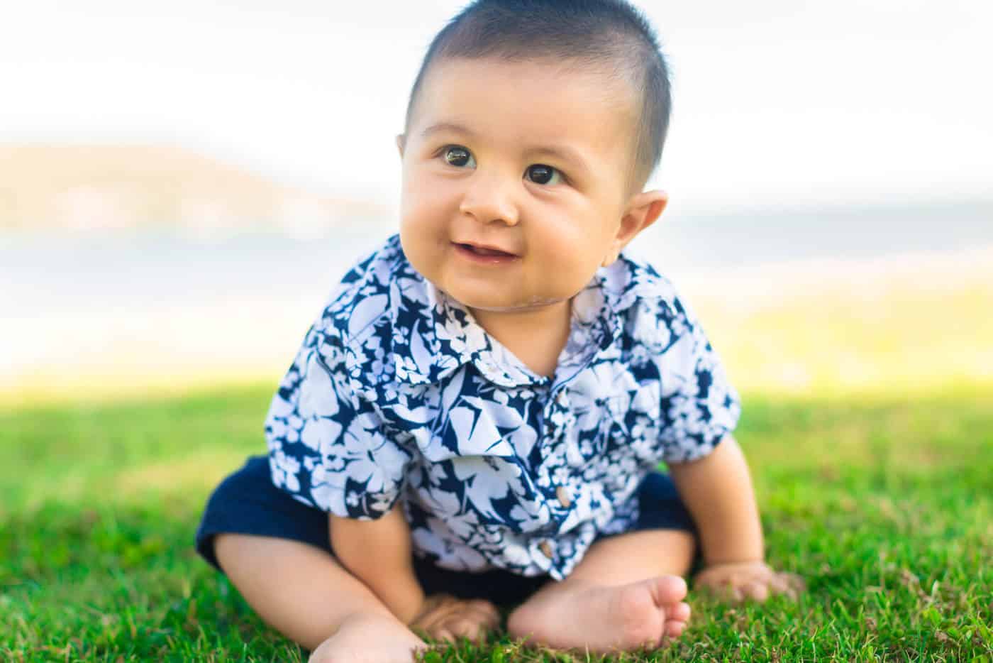 smiling baby boy sitting in grass