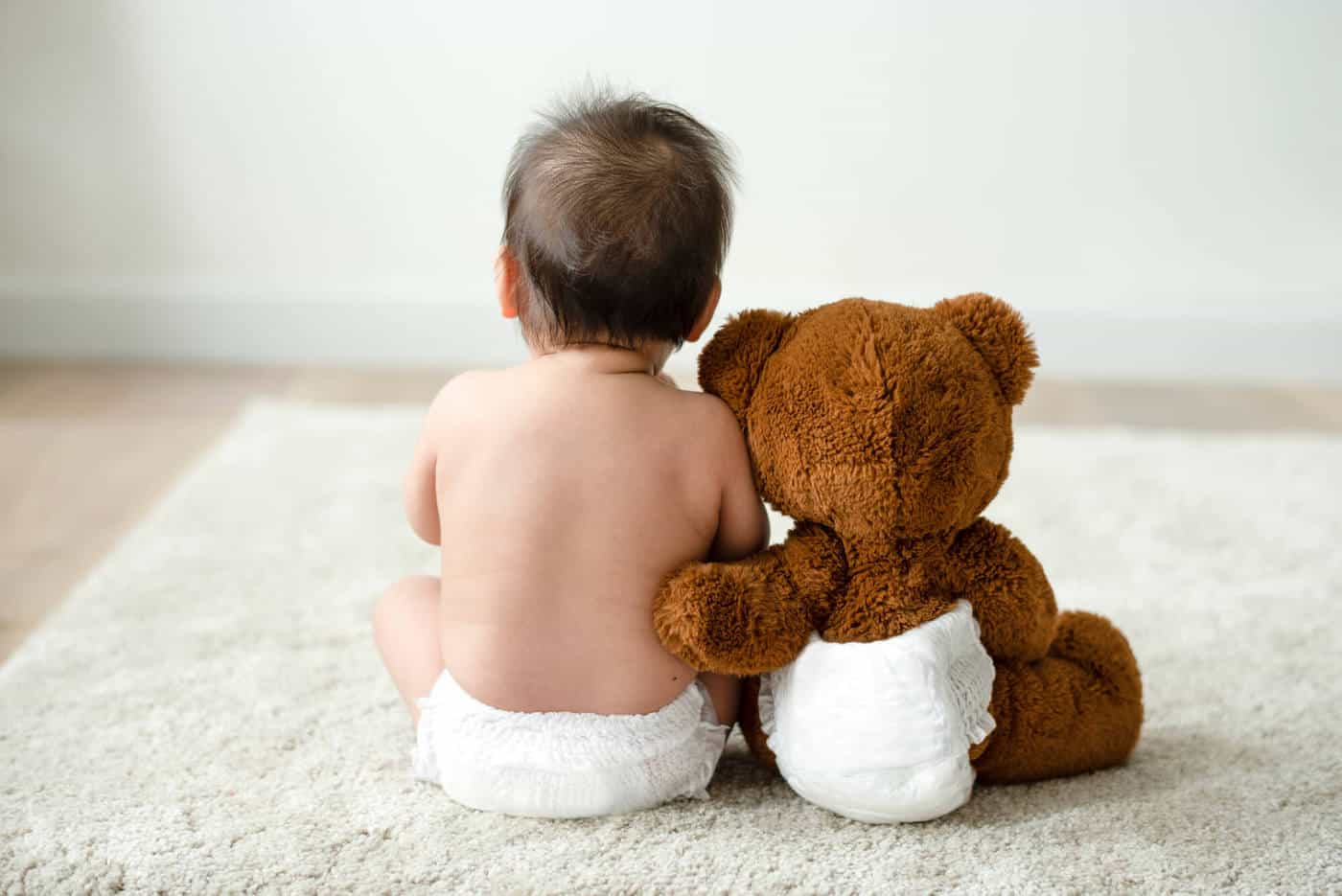 baby boy sitting with teddy bear