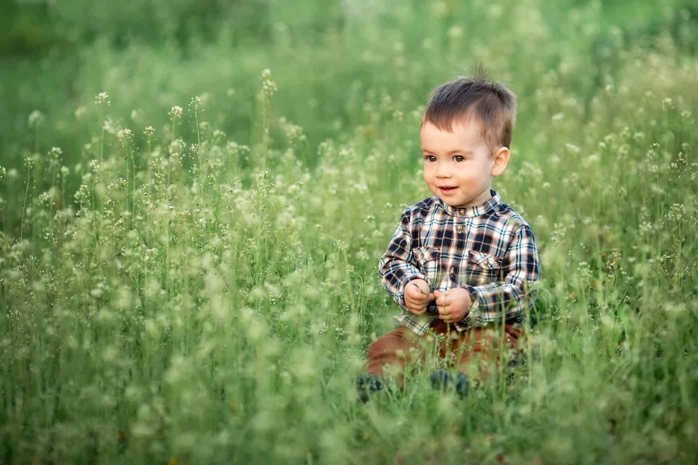 baby boy in meadow tall grass