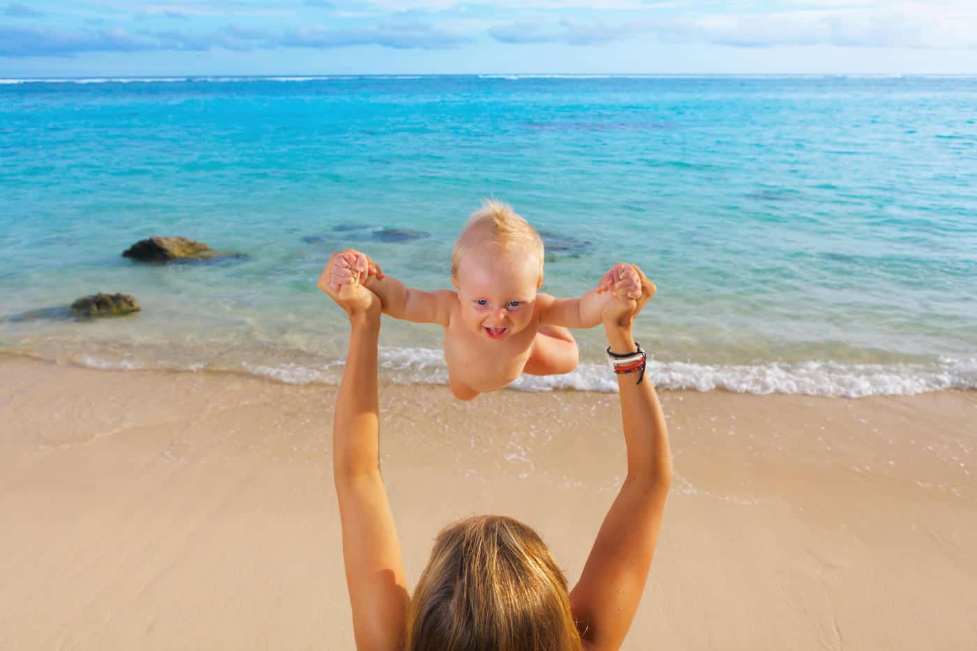 baby boy with mom on exotic beach