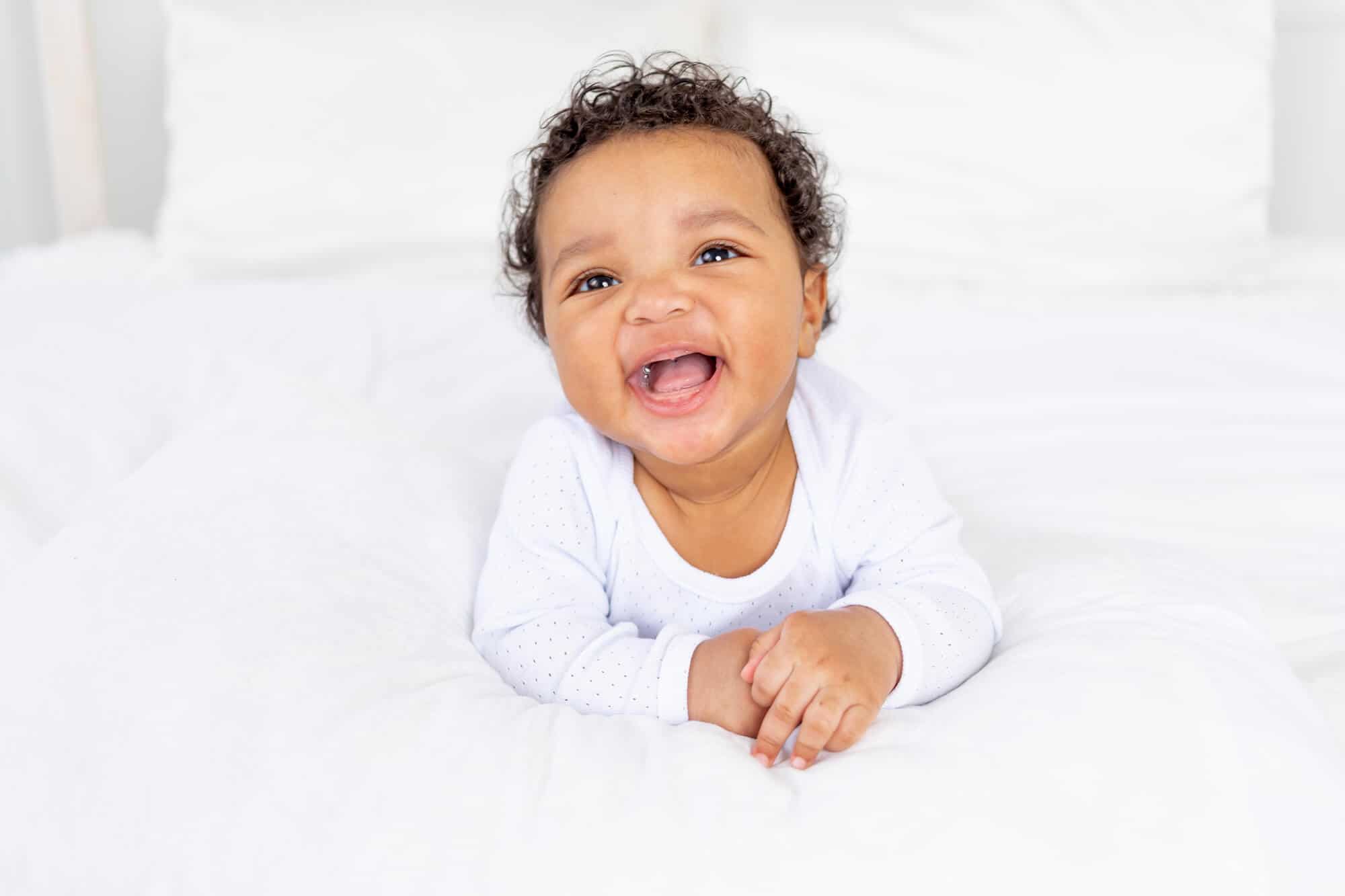 smiling baby boy lying on belly