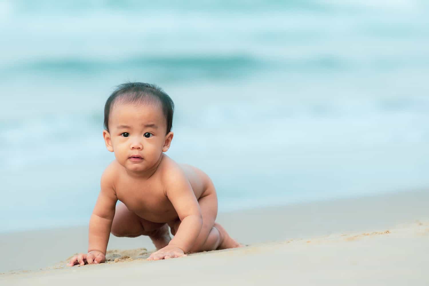 baby boy crawling beach ocean