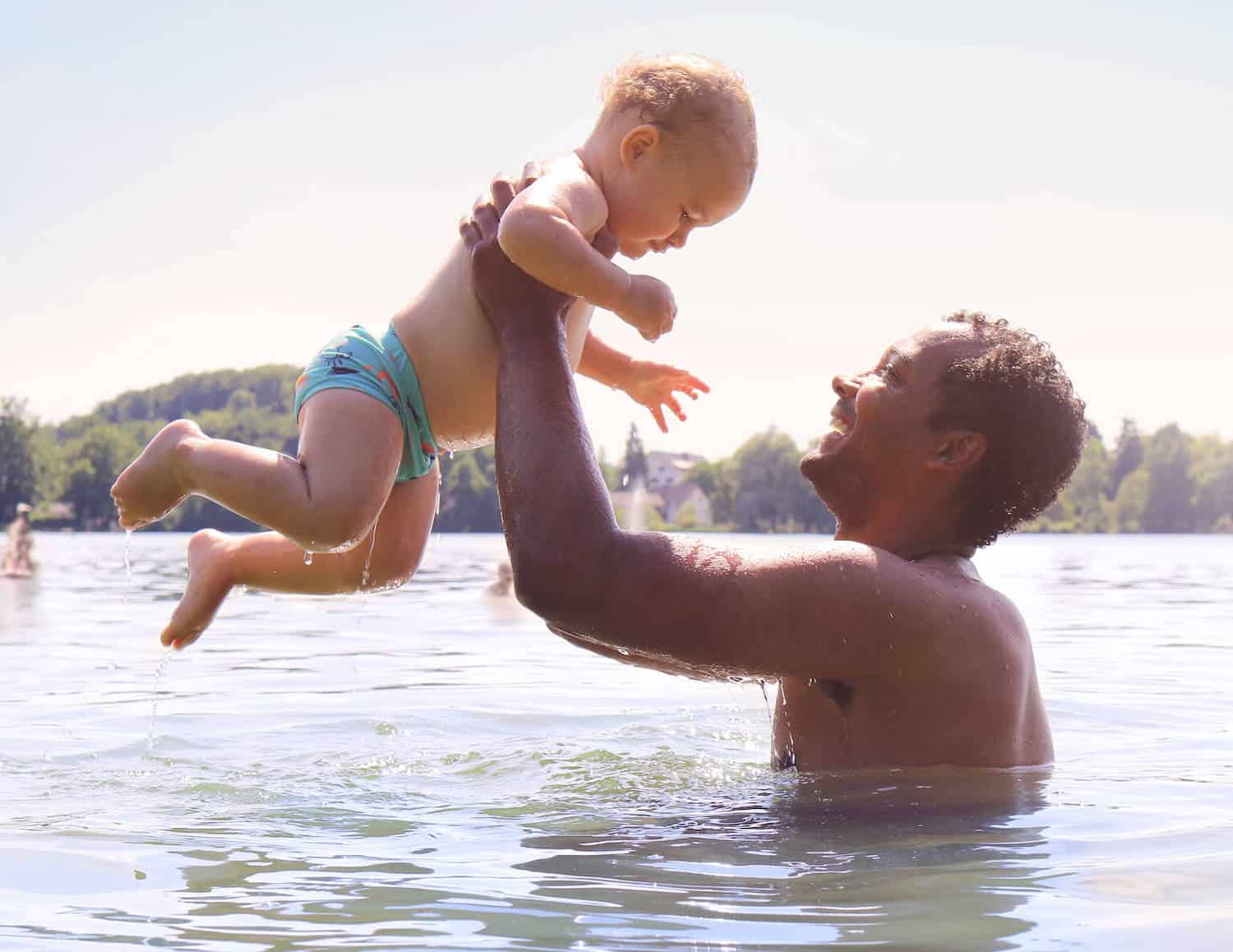 father and baby son in lake water