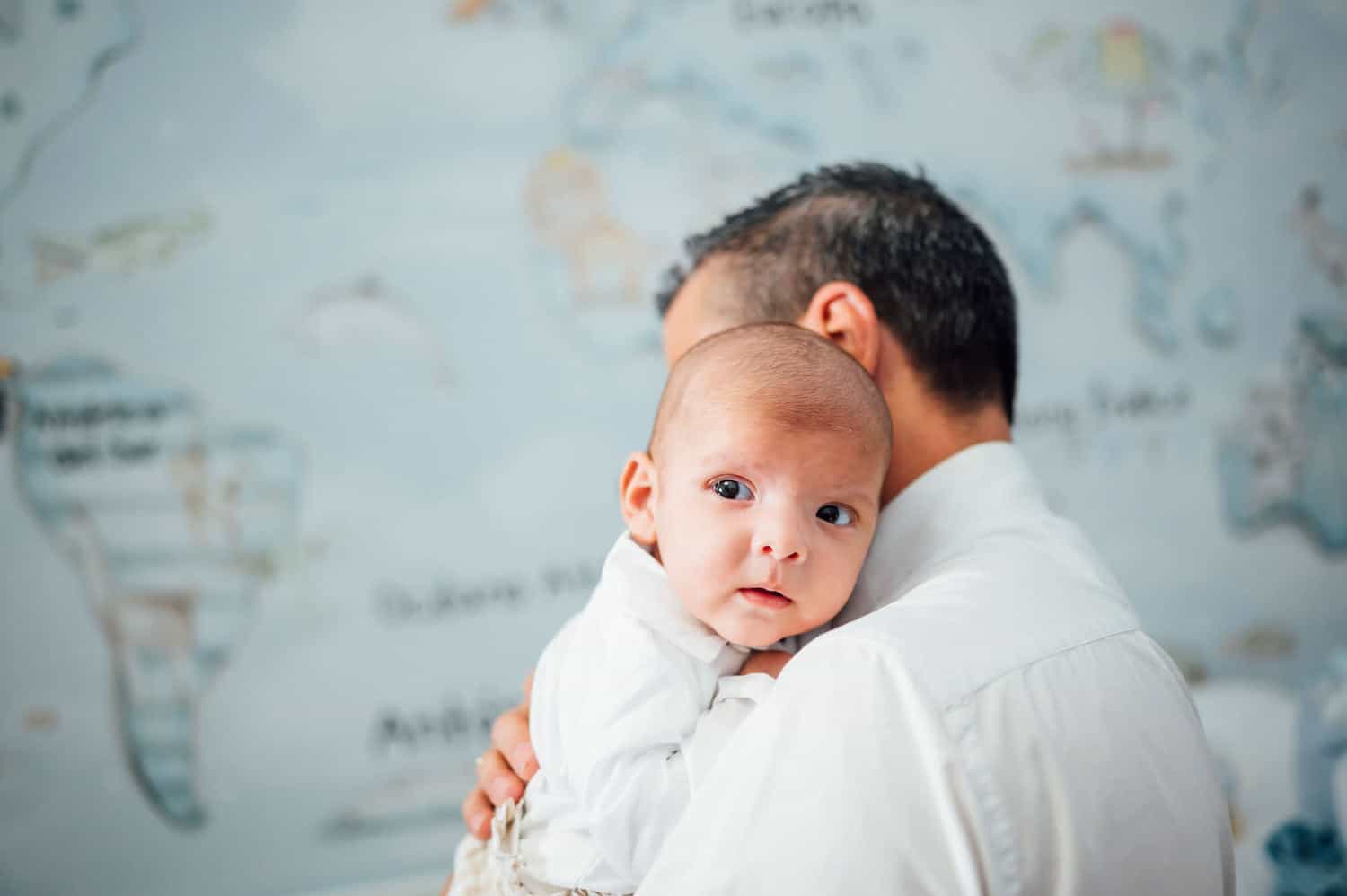 baby boy with father in front of world map