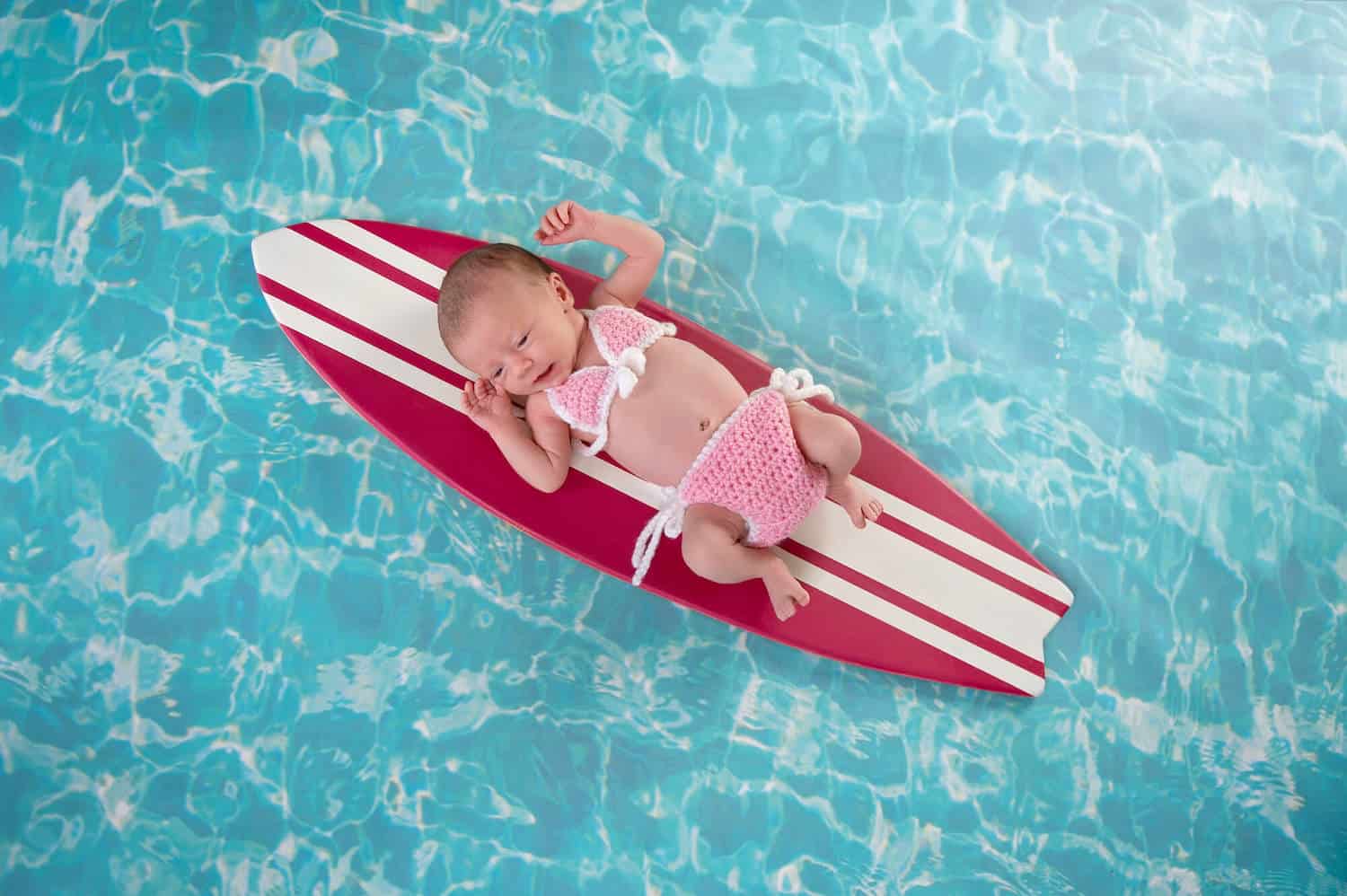 newborn baby girl bikini surf board water background