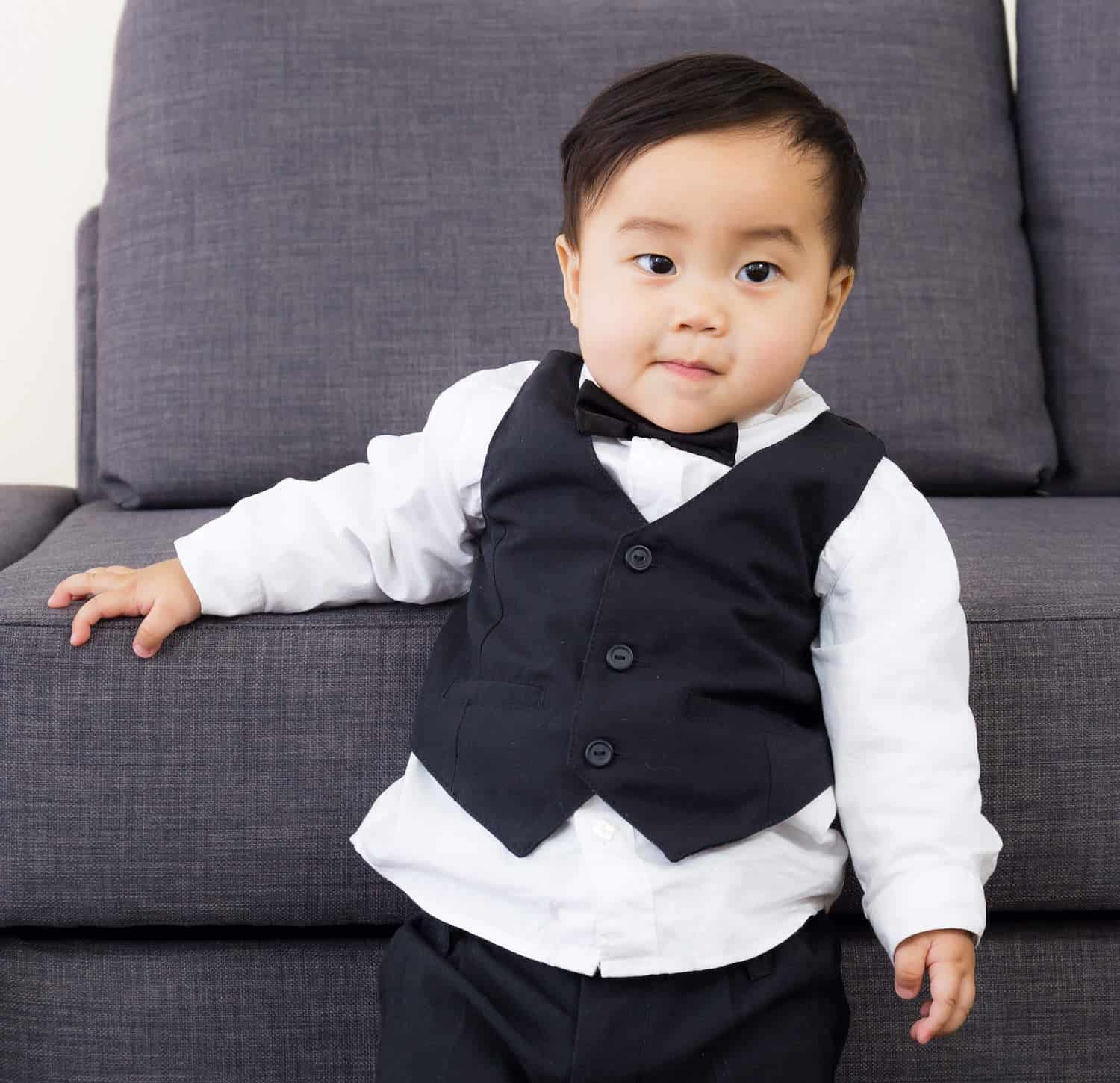 fancy baby boy standing in tuxedo
