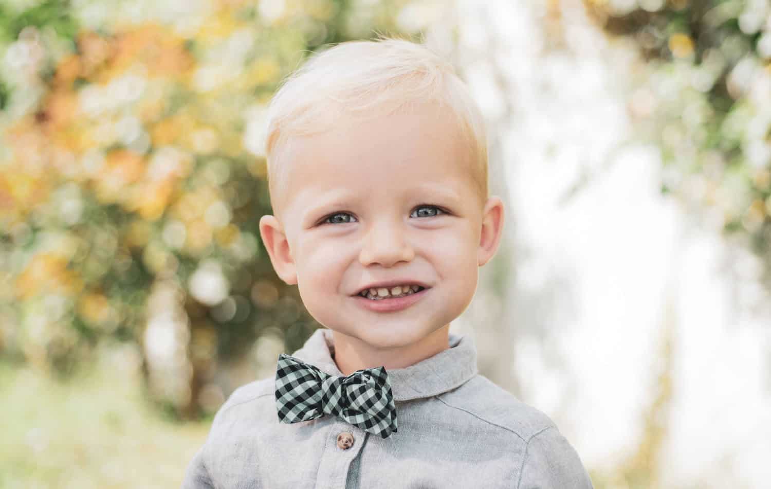 smiling toddler checkered bow tie