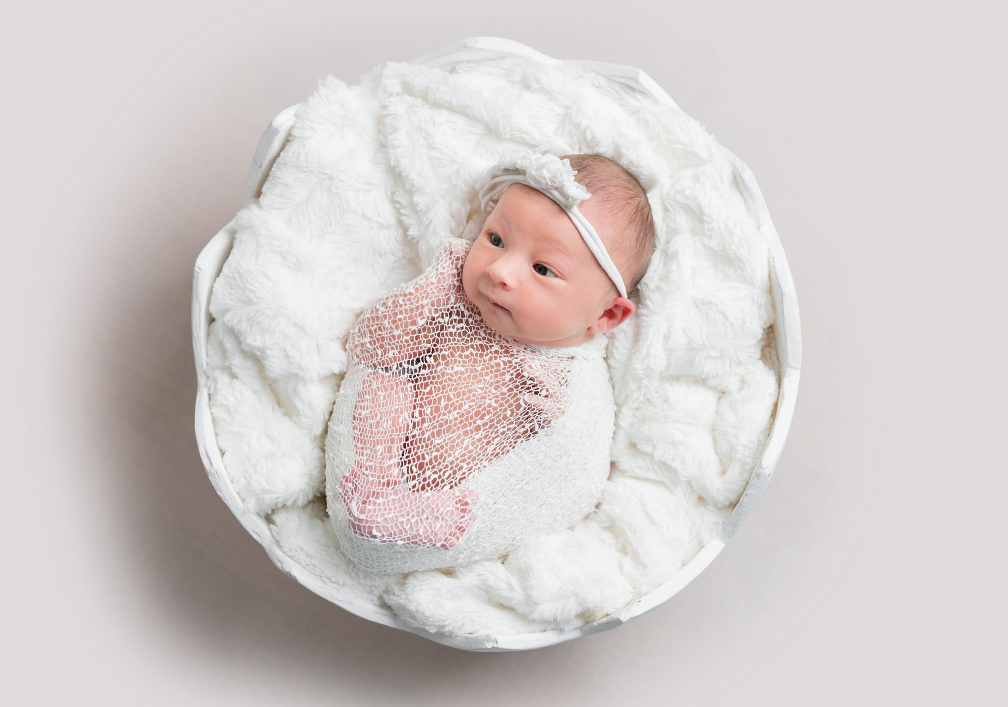 Top view of newborn baby girl laying in a bowl